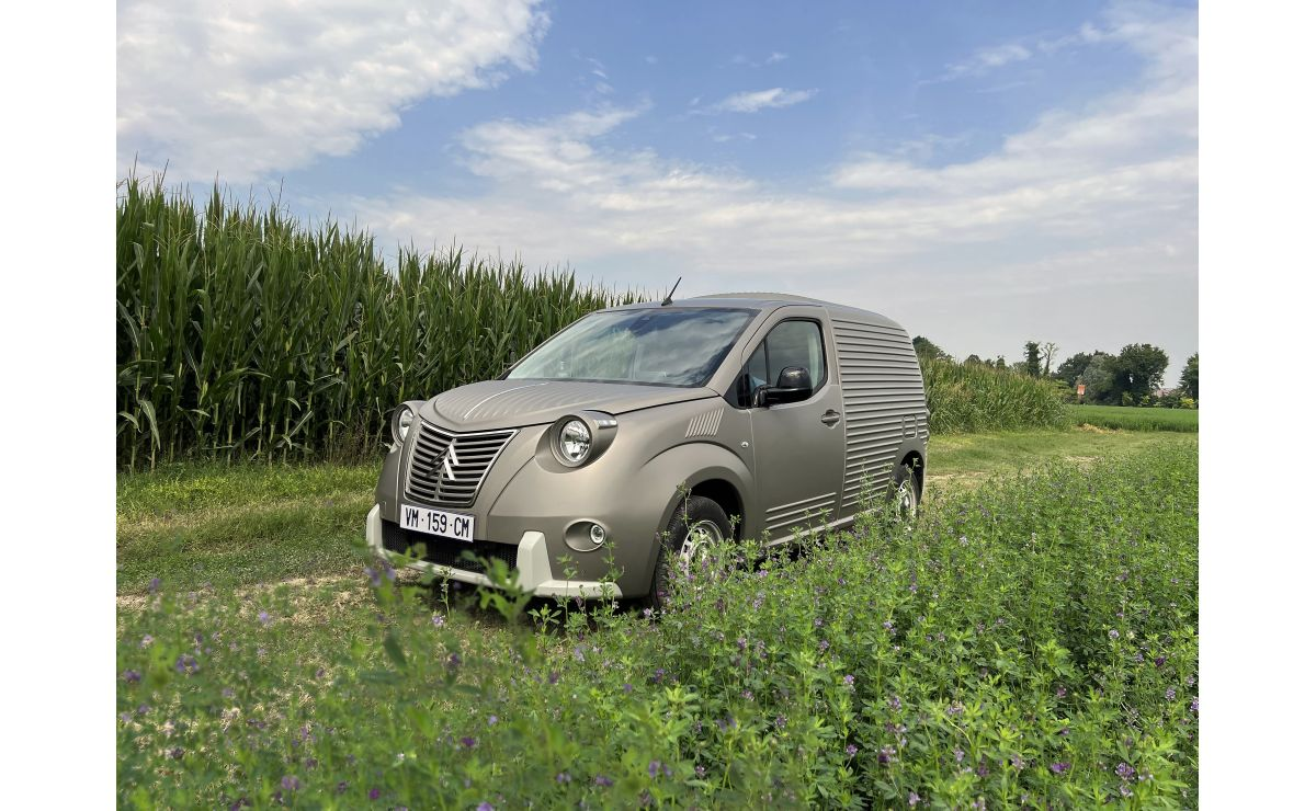 A grey Caselani Berlingo with corrugated body panels and round headlights in a field.